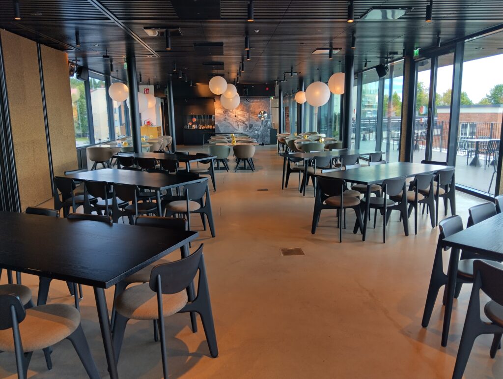 Avara tila, jossa mustia tuoleja ja pöytiä