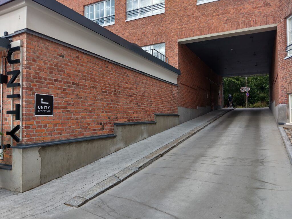 Tiilirakennusten välissä oleva luiska kohti sisäänkäyntiä